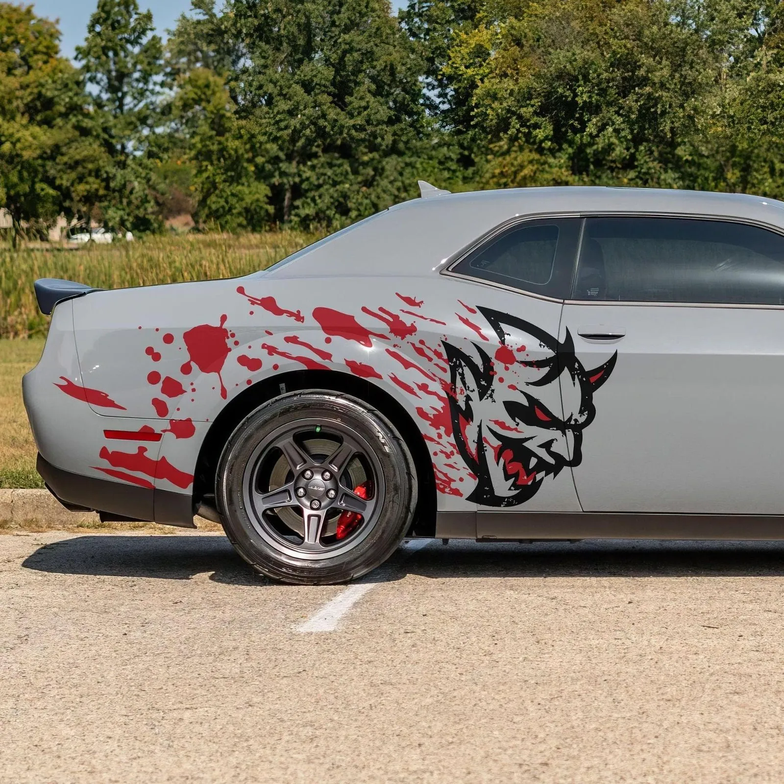 Red and black demon side graphic on a Dodge Challenger