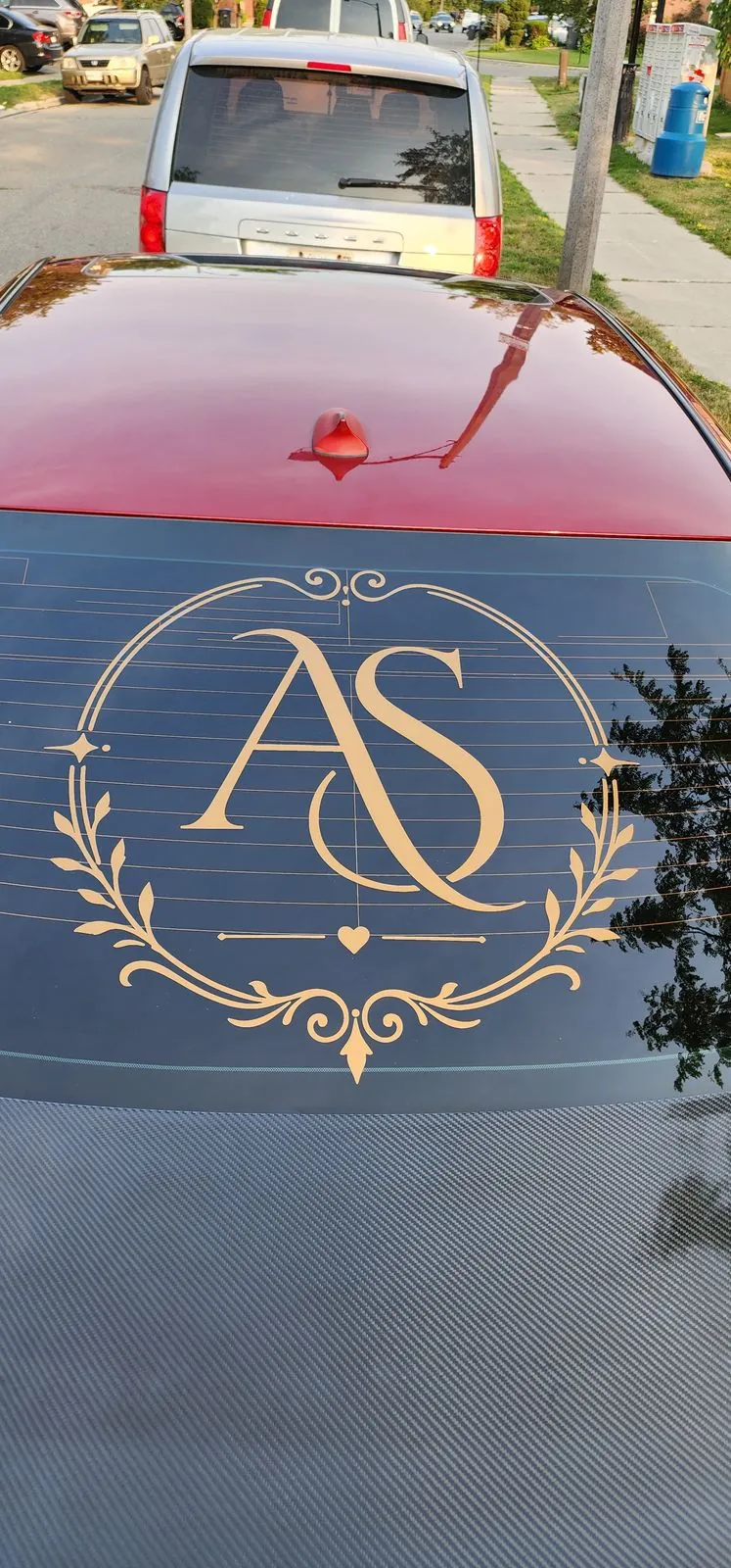 Gold monogram wreath decal on a rear windshield
