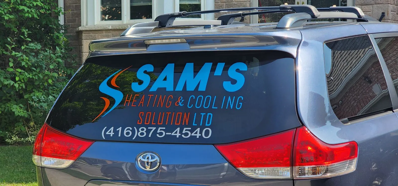 Sam's Heating & Cooling lettering on the rear window of a Toyota Sienna