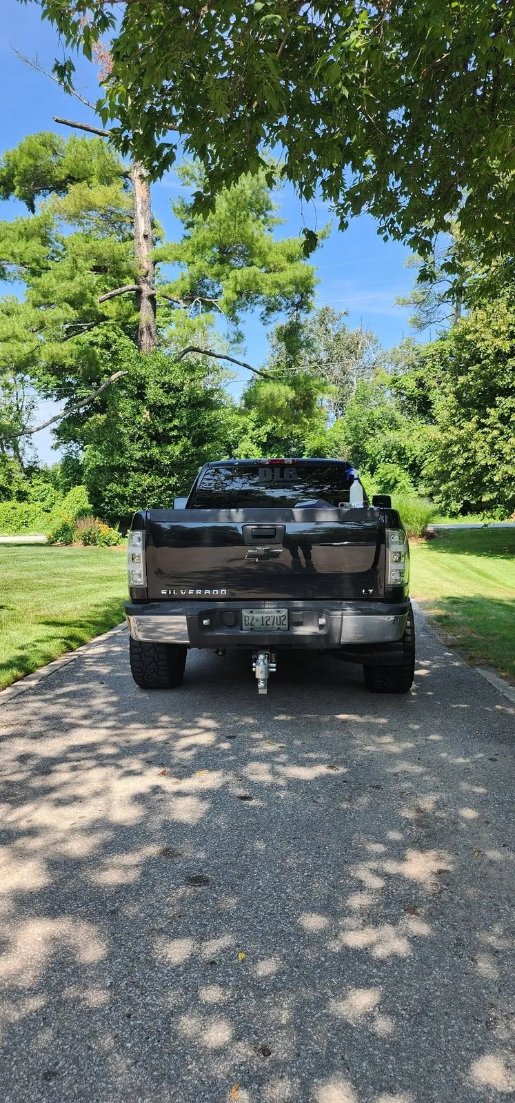 Truck rear with tinted taillights and a business window decal